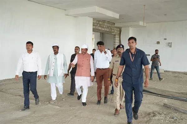 निर्माणाधीन भवन के भीतर मुख्यमंत्री डॉ. मोहन यादव अधिकारियों और सुरक्षाकर्मियों के साथ चलते हुए